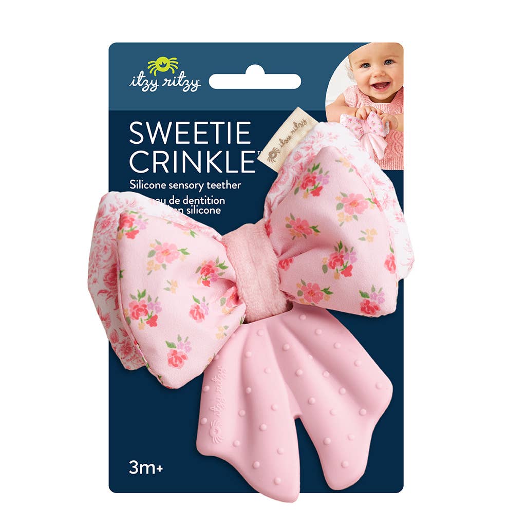 Pink crinkle teether with floral design on a blue packaging by itzy ritzy