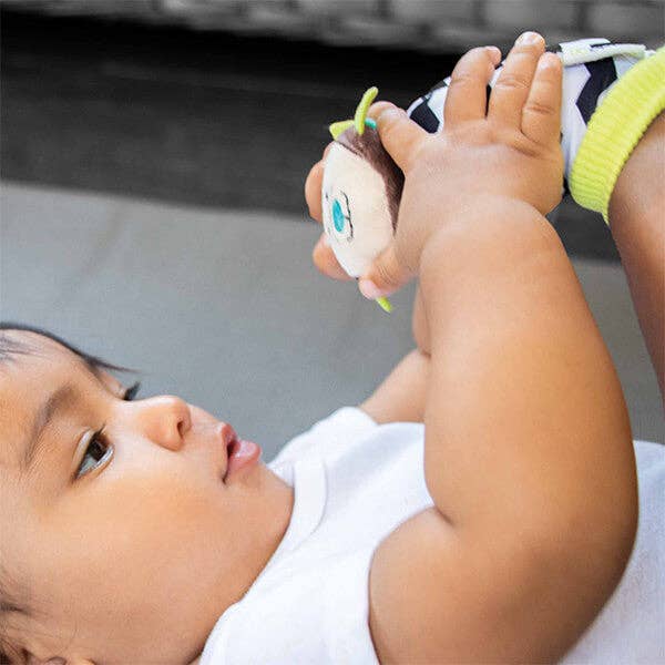 Baby lying on a surface playing with socks