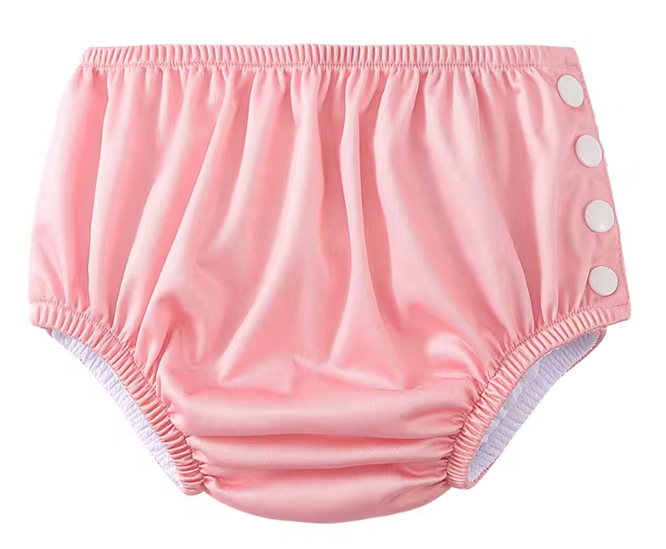Pink baby bloomers with button closure on a white background