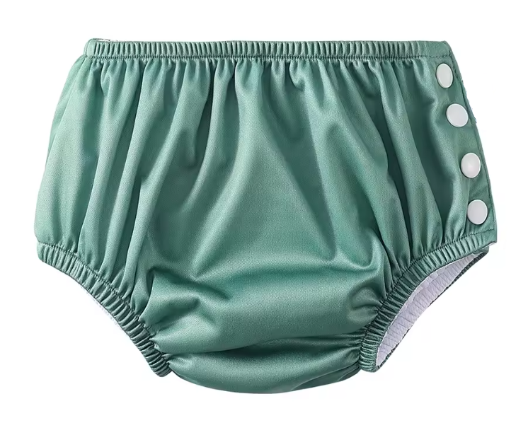 Green baby bloomers with button closure on a white background