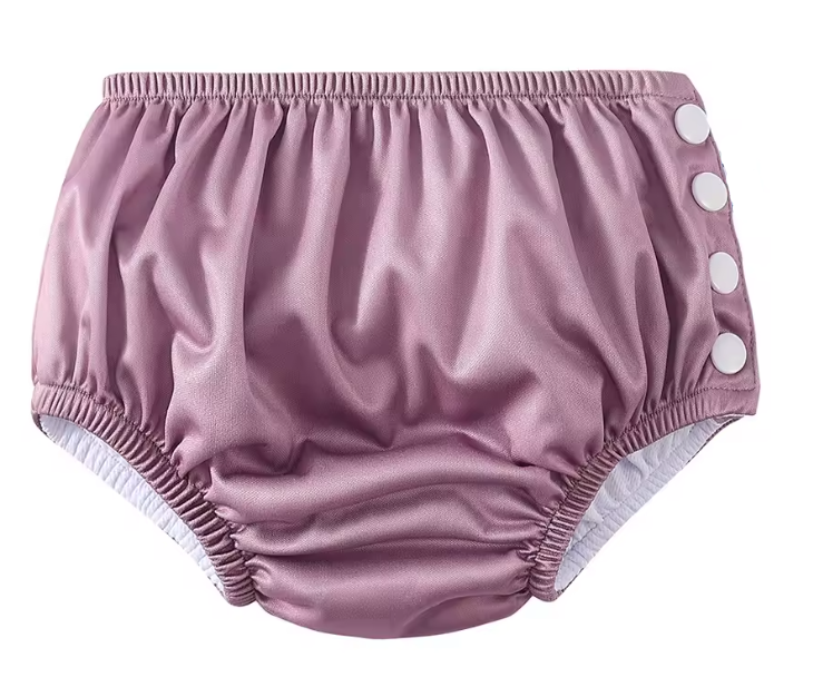 Pink baby bloomers with white buttons on a white background