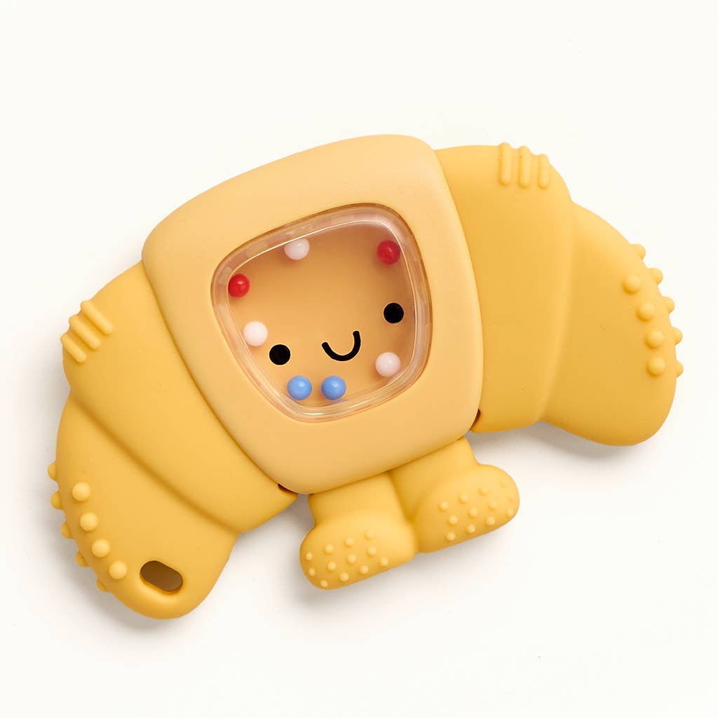 Yellow croissant with a smiling face and colorful beads inside on a white background